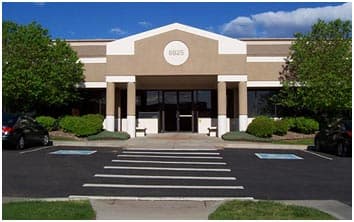 The entrance of our office building at 8925 S. Ridgeline Blvd., with its round 8925 sign over the door